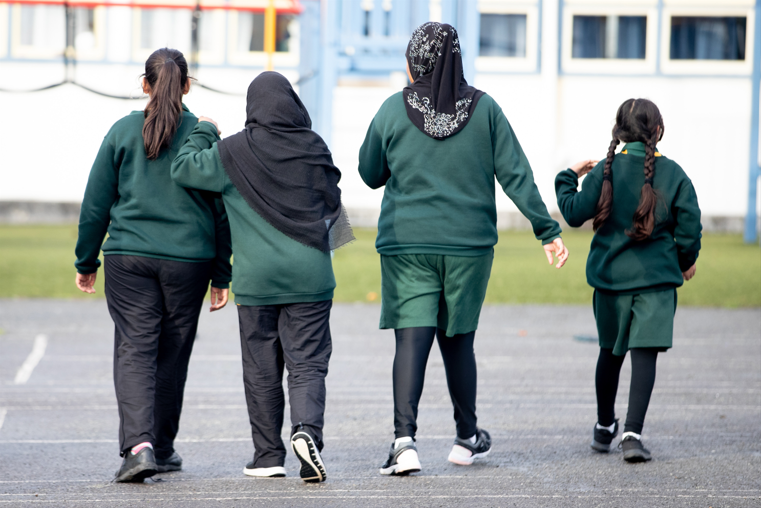 Group of students walking across a playground.