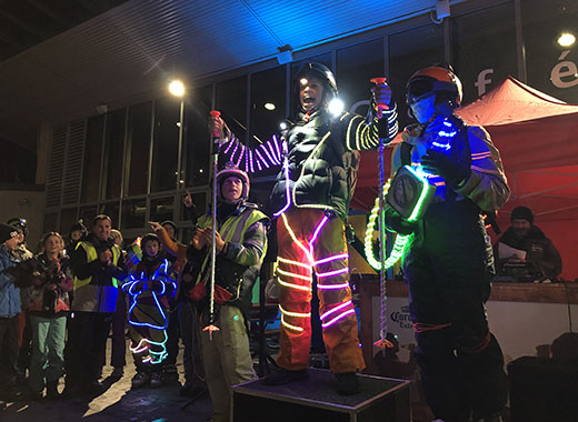 Students standing on a podium wearing their light suits.  