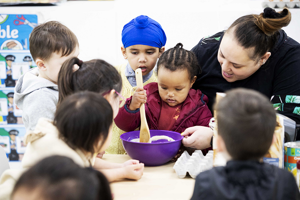 kaiako with a group of children cooking together