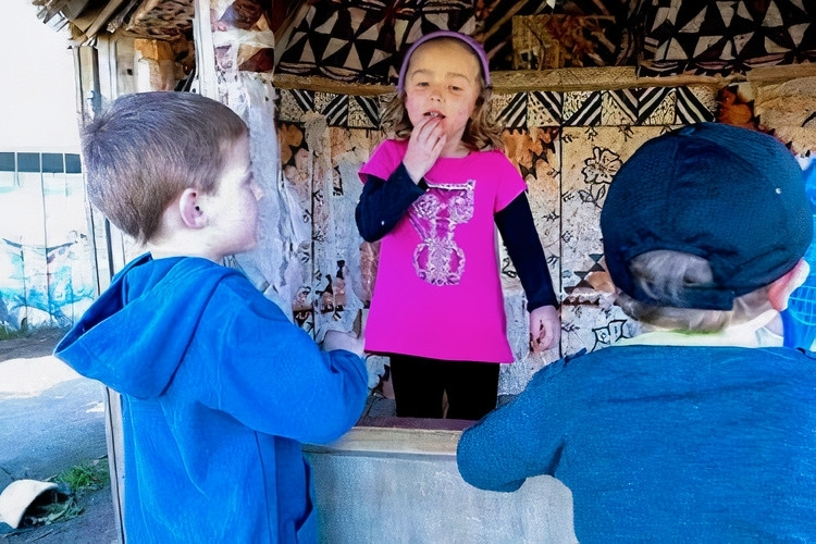 Girl using sign-language with two other children