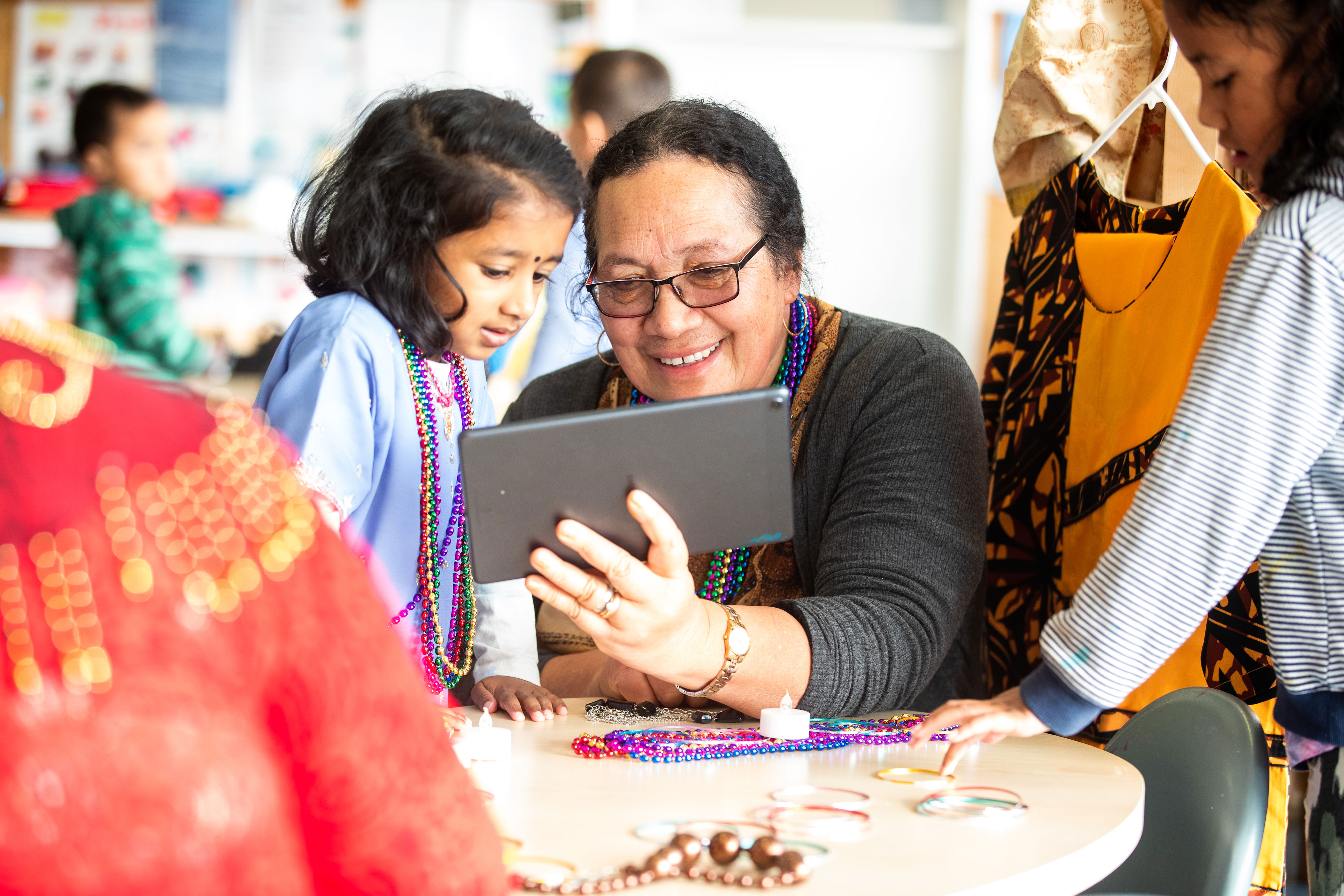 Kaiako and a child working together with a computer tablet