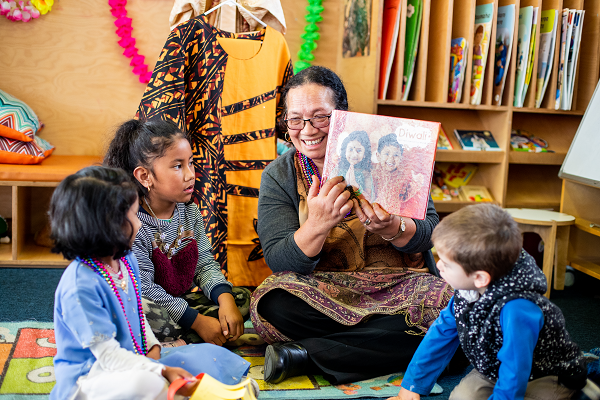 A Kaiako sharing a book about Diwali with a group of children