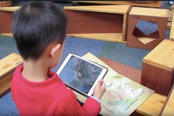 A child using a tablet to look at a map of an area