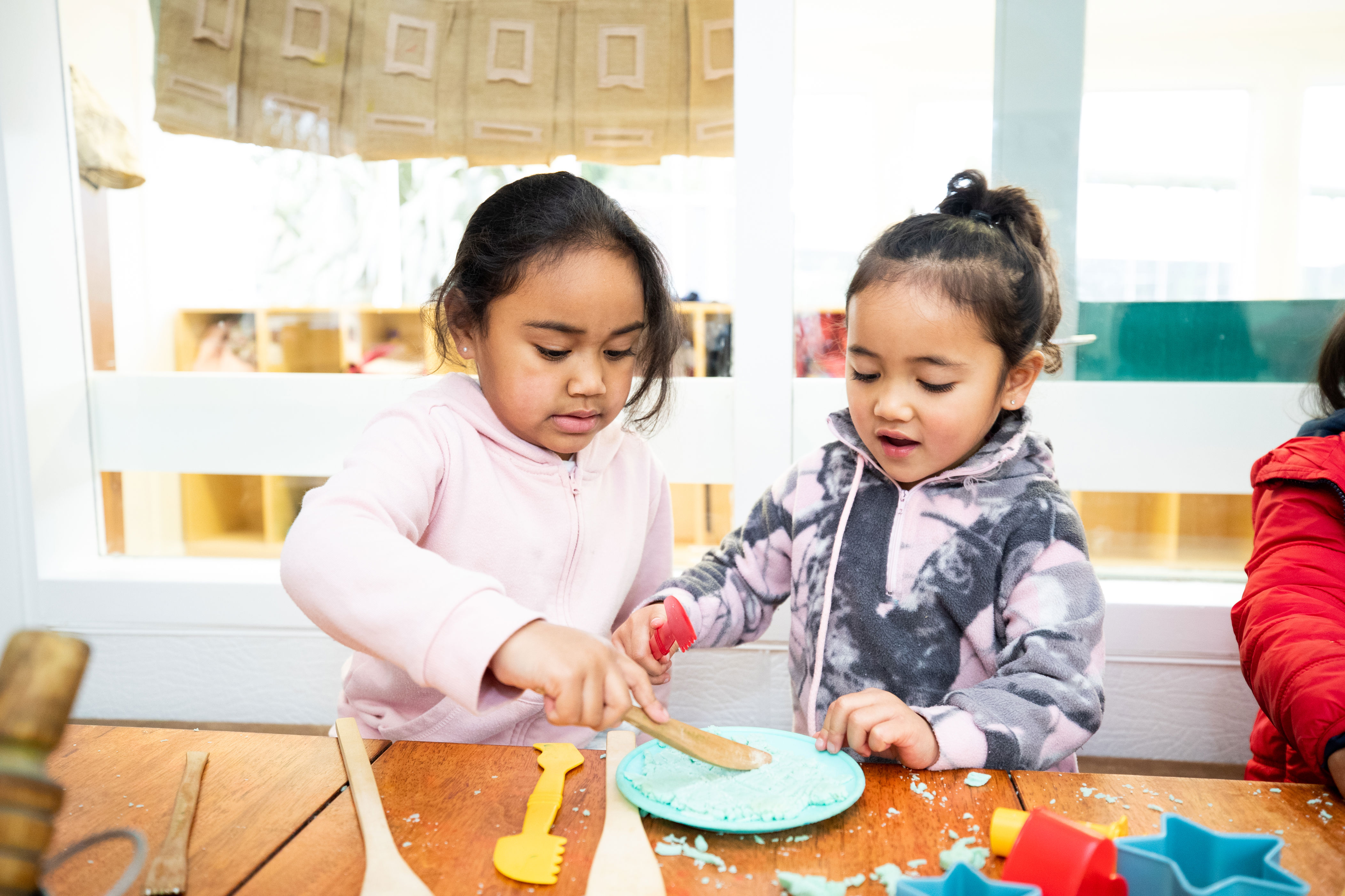 Two children playing together with play dough