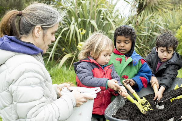 Kaiako with tamariki gardening