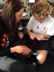 Erin showing a student a tāniko technique.