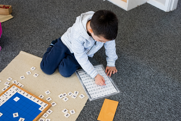 a child playing with a maths game on the floor