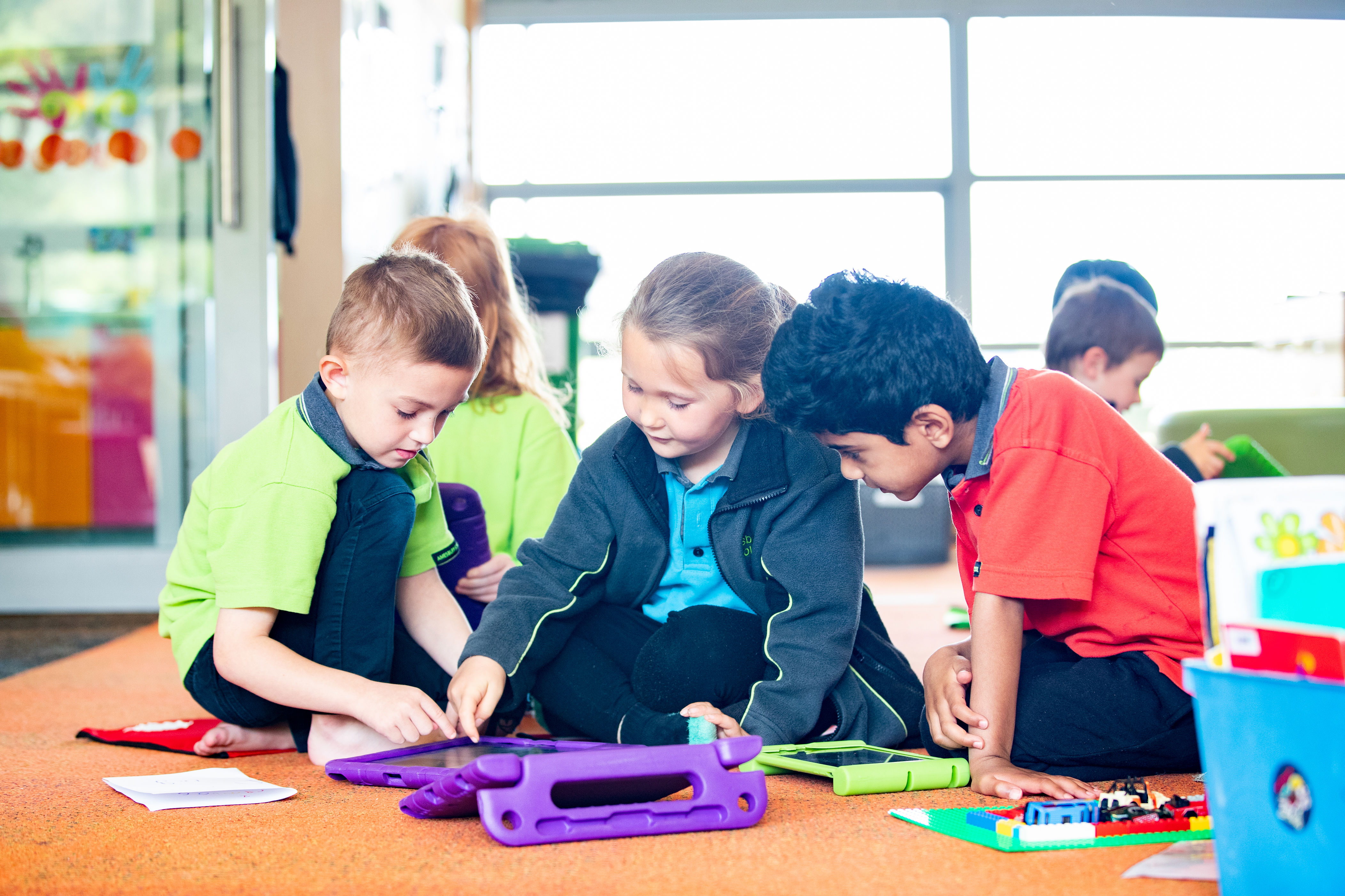 A small group of ākonga in the classroom interacting with a tablet.