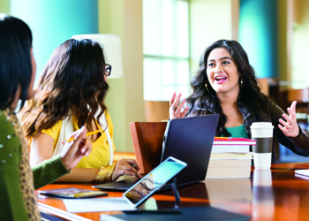 Three teachers talking around a desk