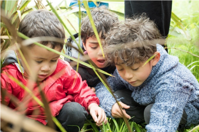 Three children outside gardening