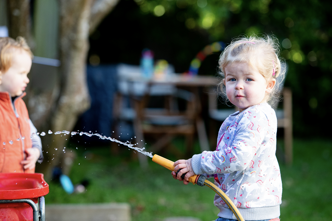 young tamariki playing with hose