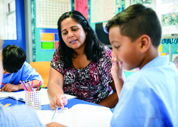 Teacher and students talking at a desk