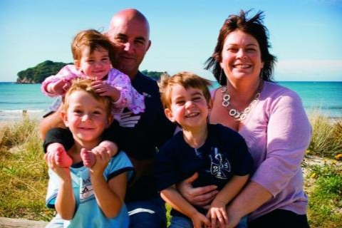 Two adults and three children on beach