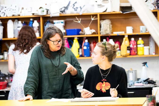 A kaiako working with a ākonga in an art studio.