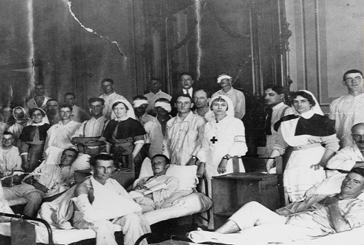 Black and white snapshot of an army hospitalc with nurses caring for injured soldiers.