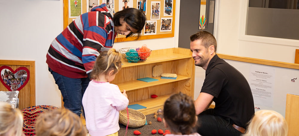 Father with child and kaiako in play area