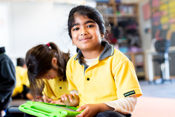 Girl smiling and looking up with laptop on her lap