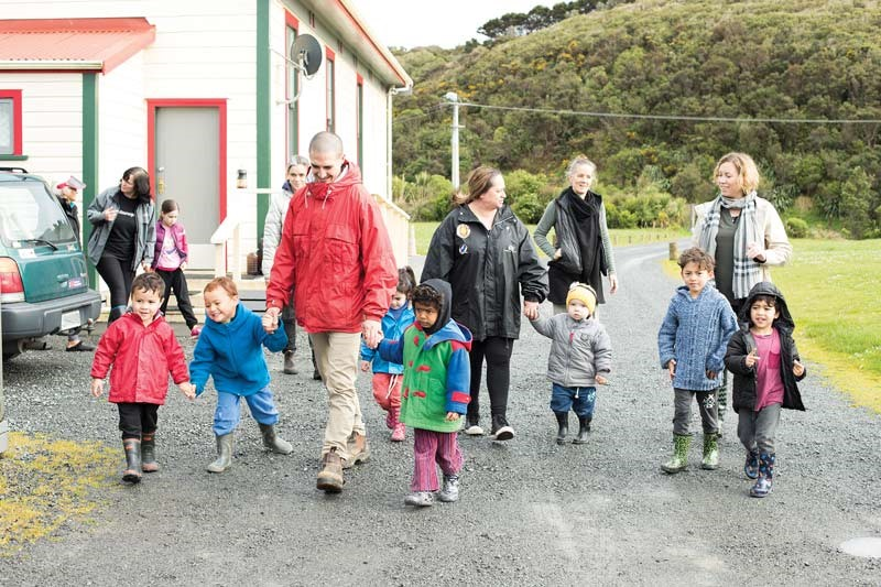 Whānau and kaiako walking together with a group of children.