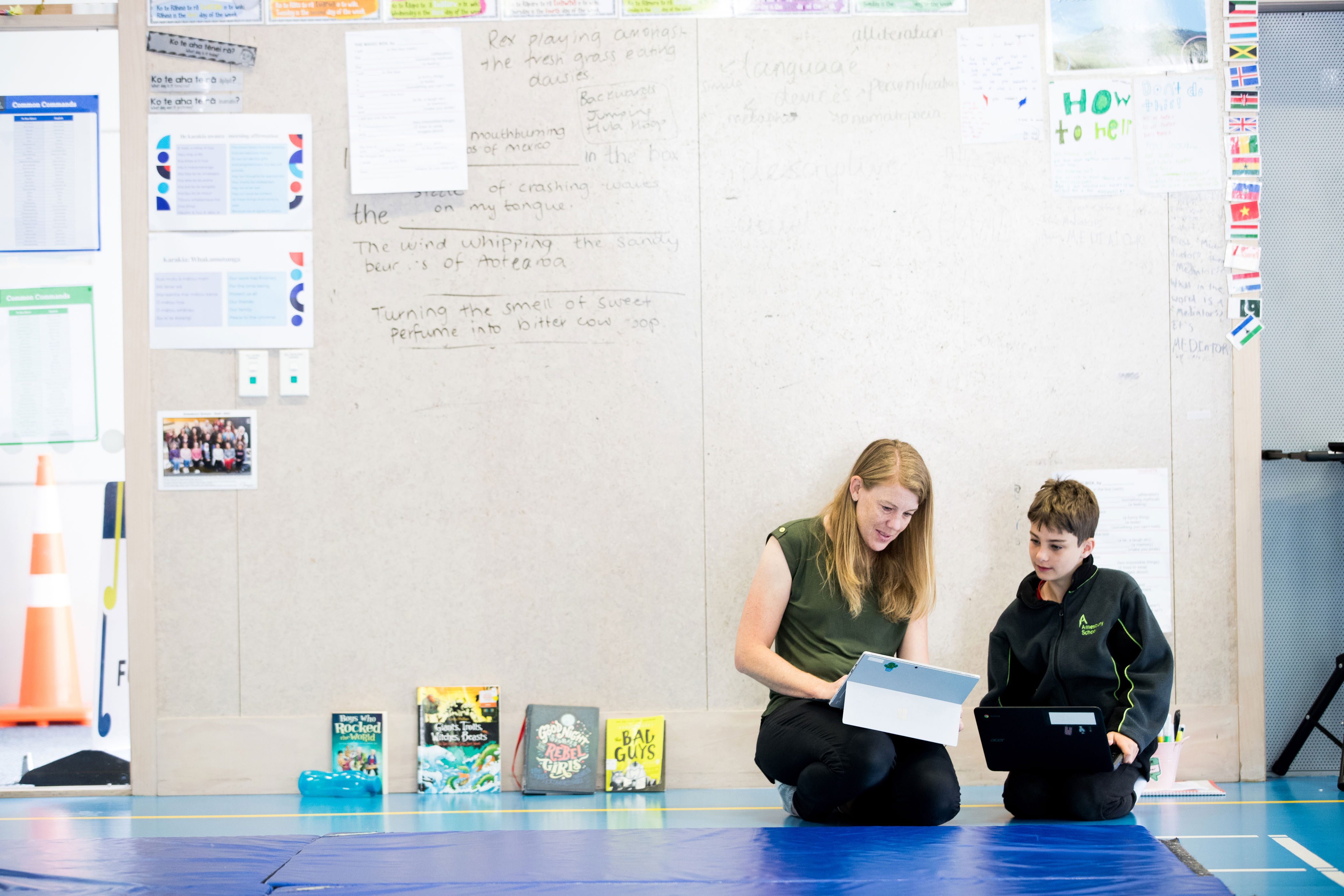 student and  teacher working together on a computer and ipad