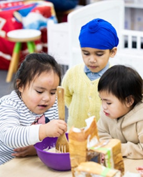 Three children are baking together.