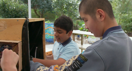 Two students working on the self-watering plant system.png