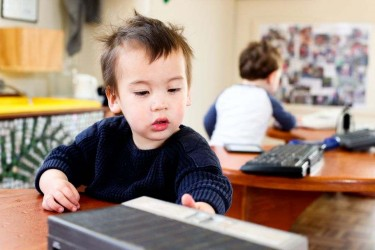 A toddler looking at a book.