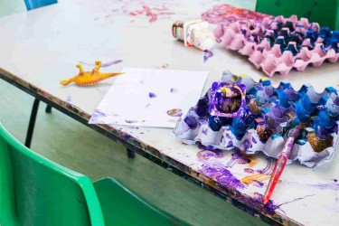 A child's painted egg cartons lying on a table.