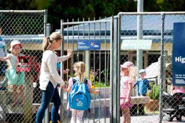 A parent walking through the gate with a child at Four Seasons Rudolf Steiner Kindergarten.