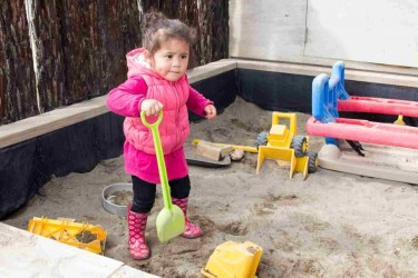 A child playing in a sandpit.