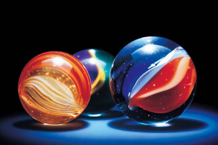 Close up photograph of three colourful glass marbles.