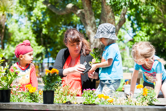 Three children and a woman gardening