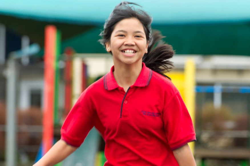 A girl smiling and running.