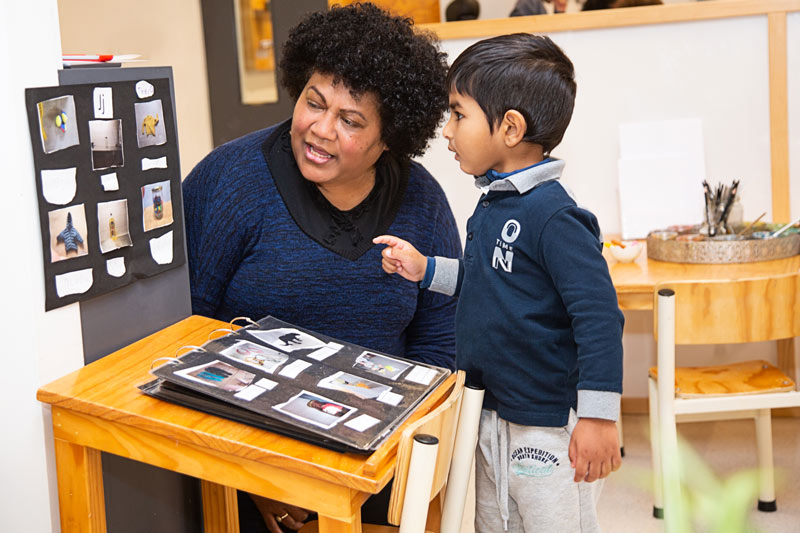 A kaiako talks with a tamariki about the pictures collected that start with J