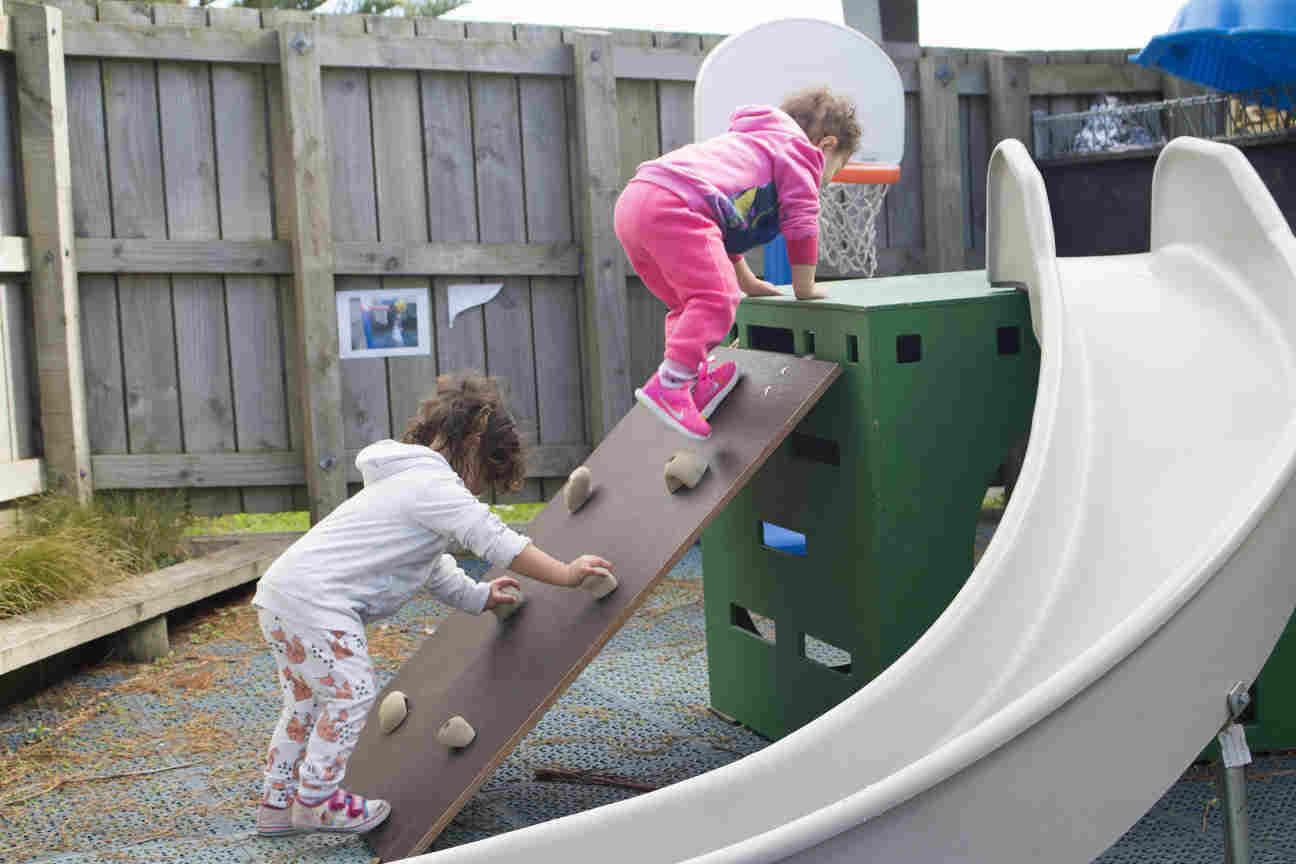 Two children playing on a slide