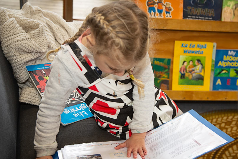 Child looking at their learning story book