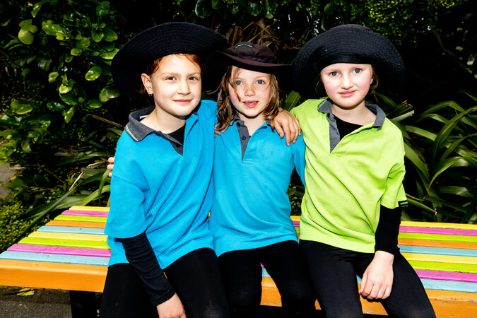 Three ākonga pose for the camera, smiling, with their arms around each other. 