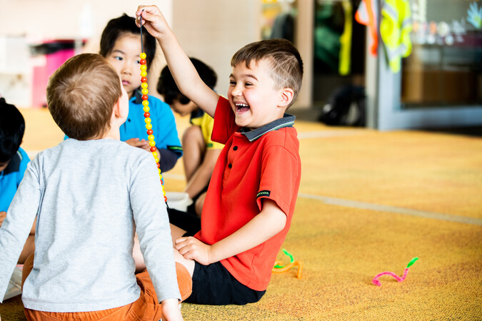 Group of akōnga engaged in a class activity using coloured beads.jpg