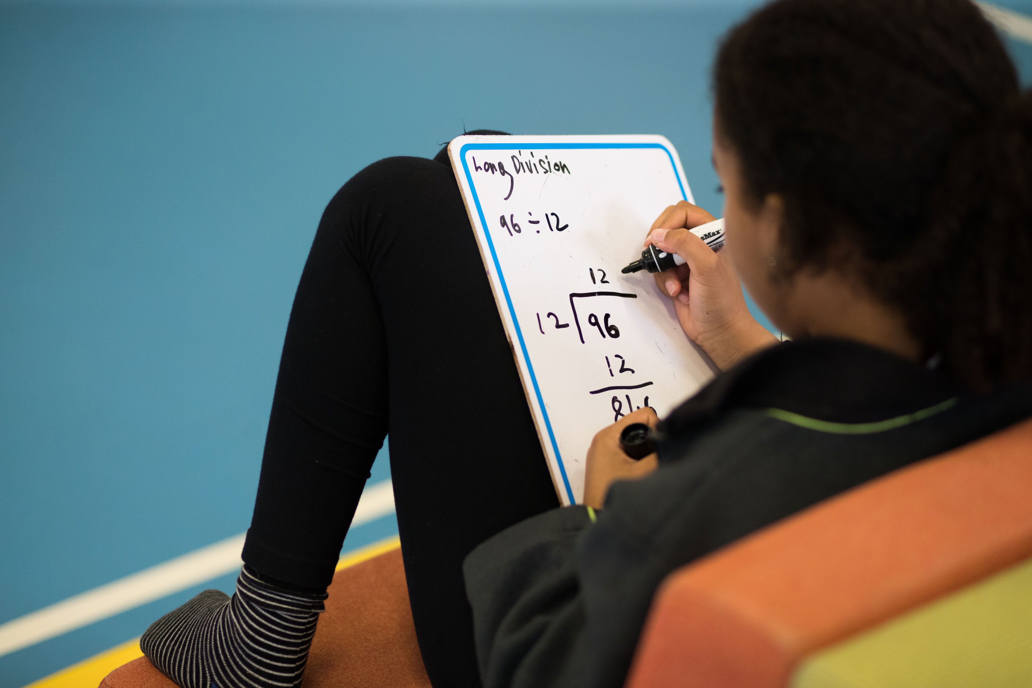 student doing maths equations on a whiteboard