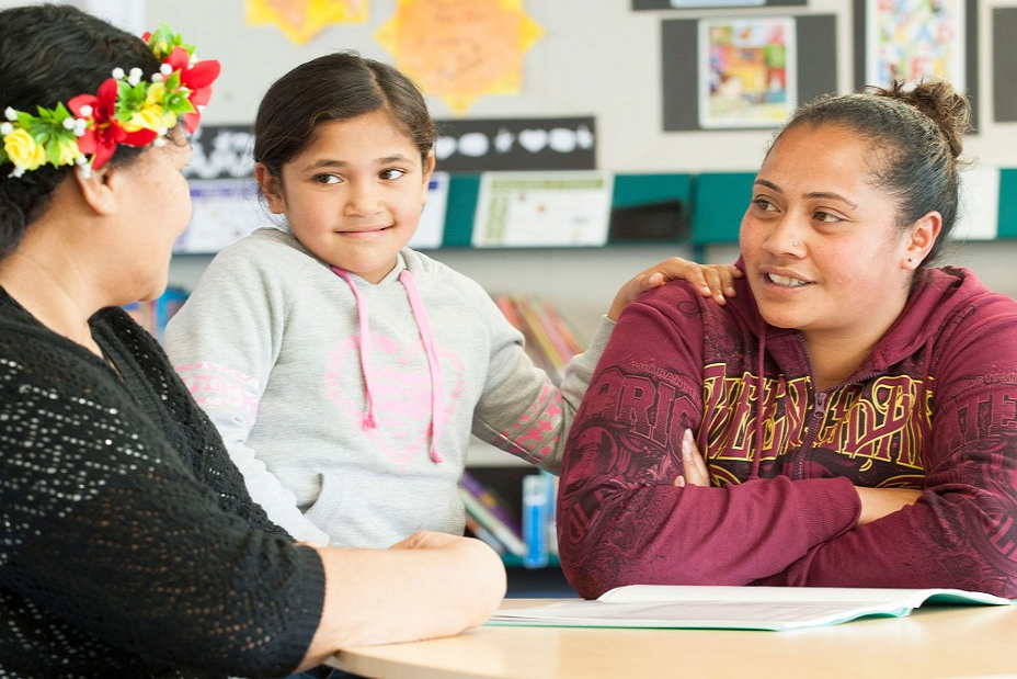 A teacher talking with a parent and child.