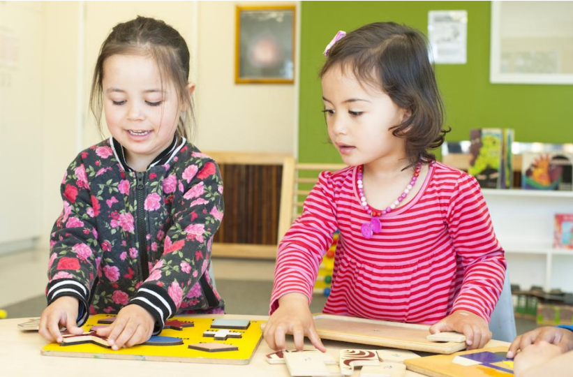 Two young girls doing a puzzle together