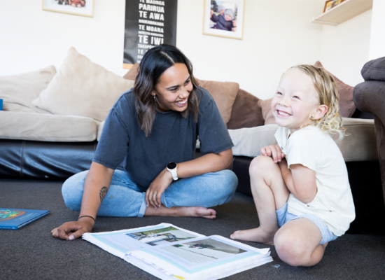 Teacher sitting on floor with small child