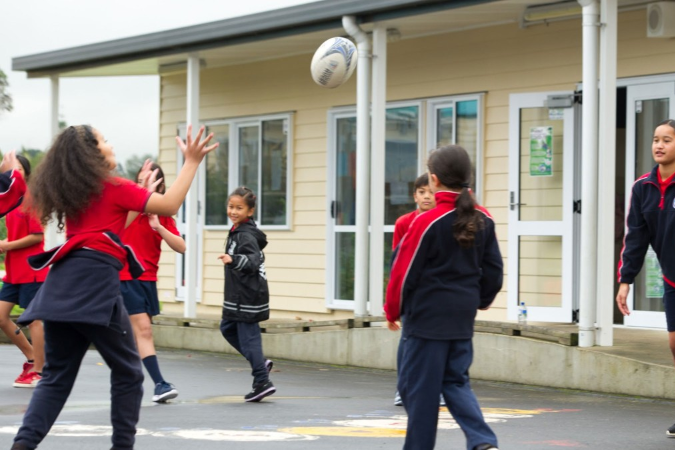 Children playing with rugby ball.