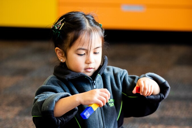 young child playing with colour blocks