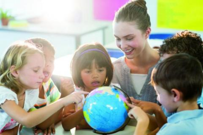 Children and teacher looking at world globe