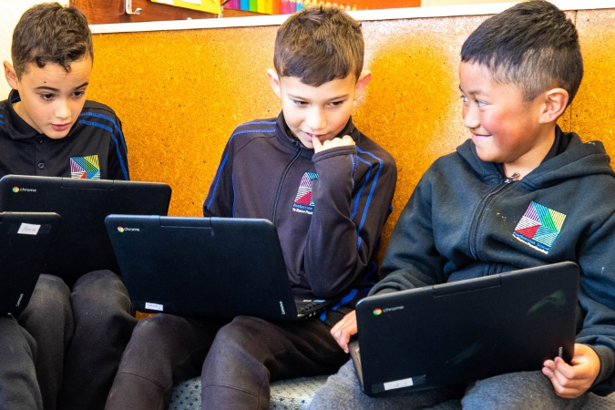 Three students working on laptops.