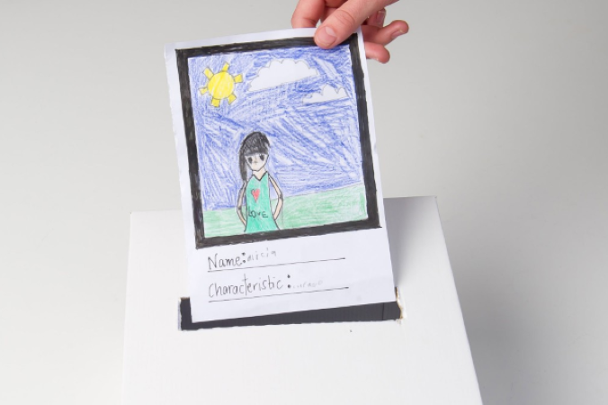 A kids drawing being put into a box.