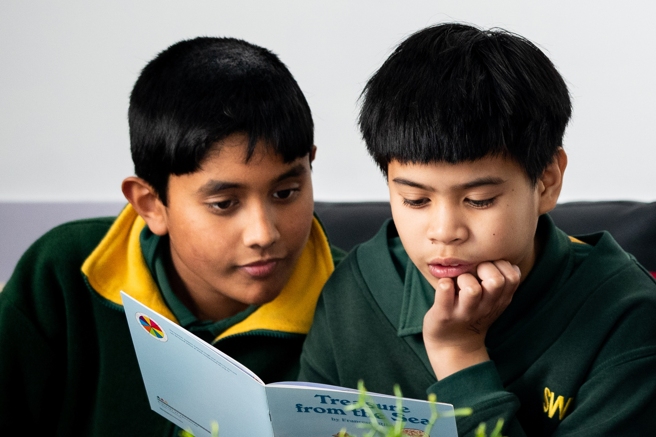 Two students reading a book together