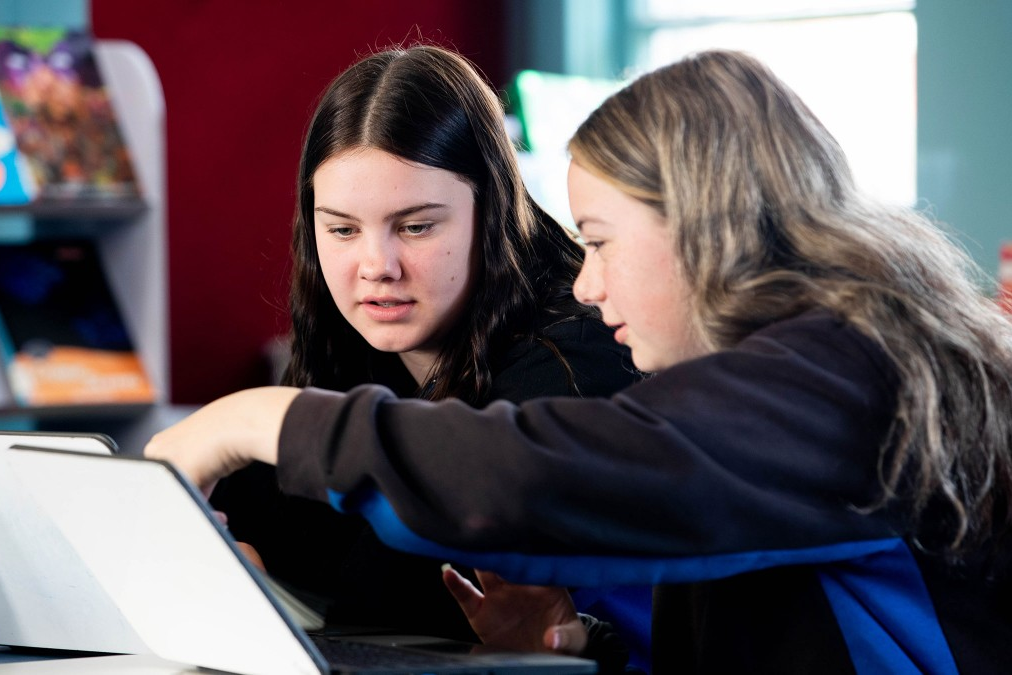 Two students working on a laptop.