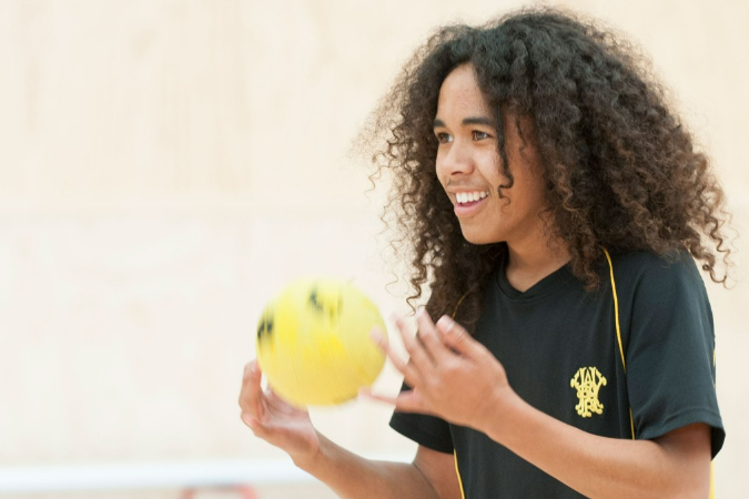 A teenage student preparing to throw a miniball.