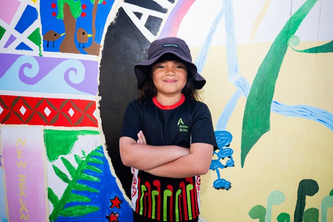 Child standing in front of a painted mural